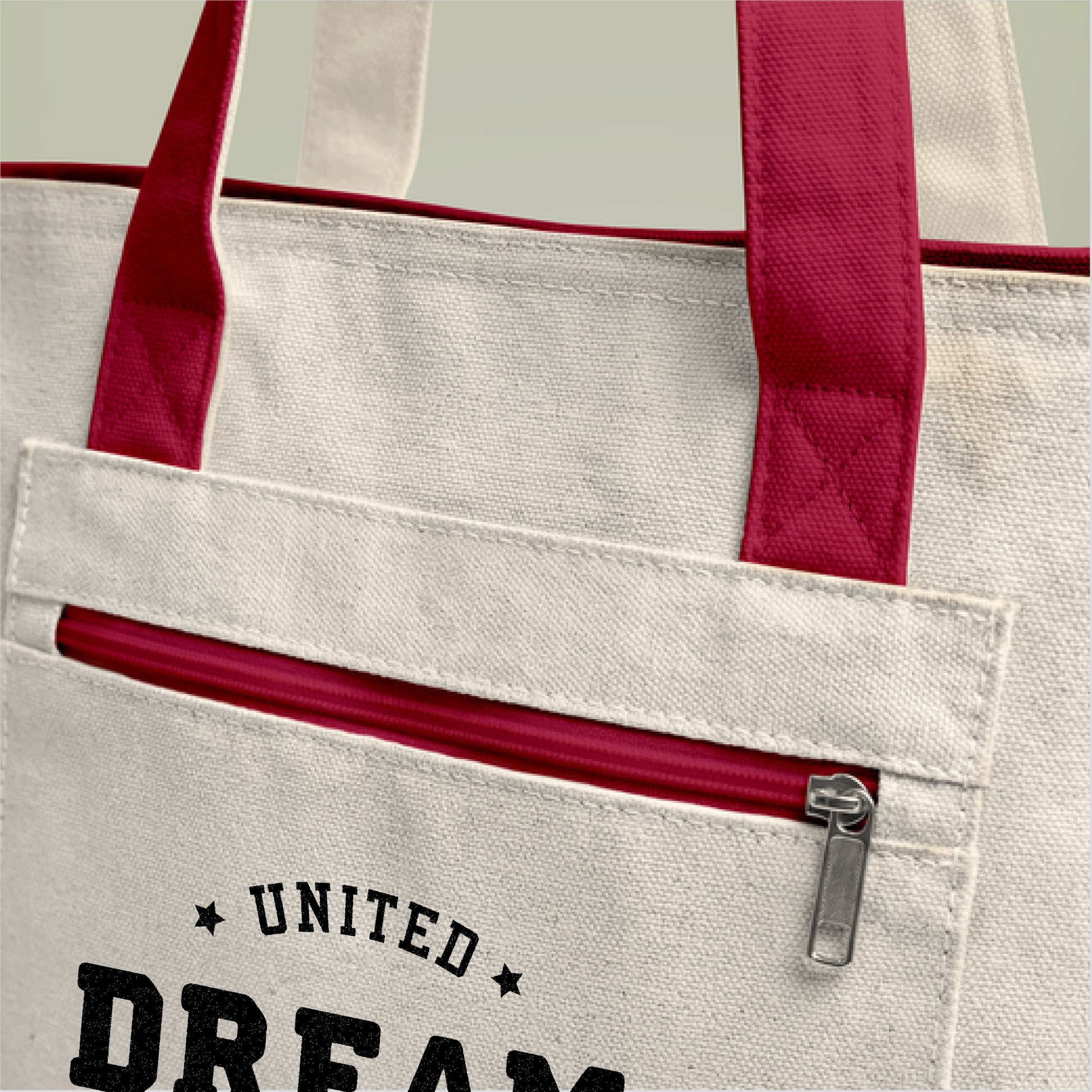Beige tote bag with red handles and zipper, featuring 'Dream, Toted' United Day Dreamers text.