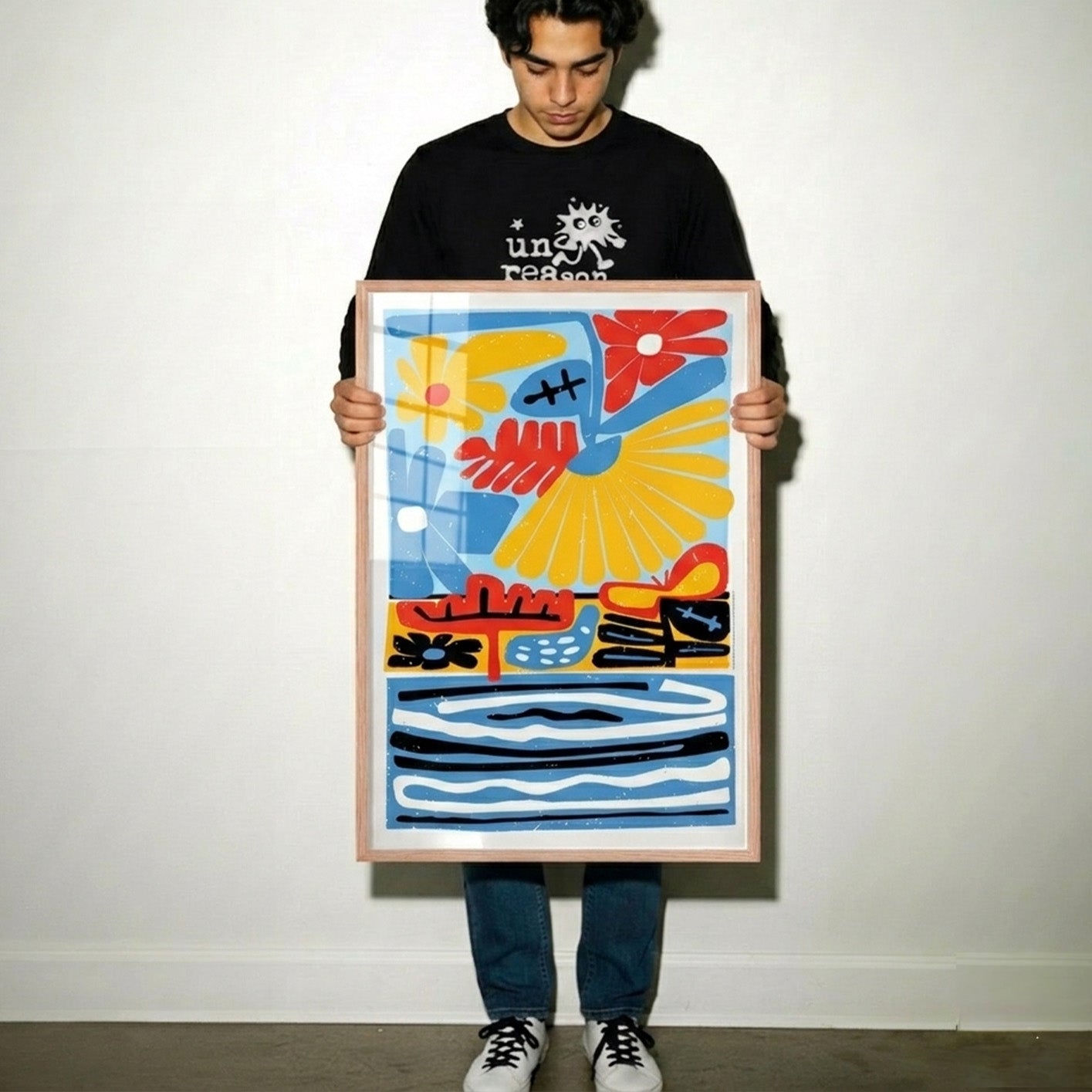 Man holding a colorful abstract painting against a plain background
