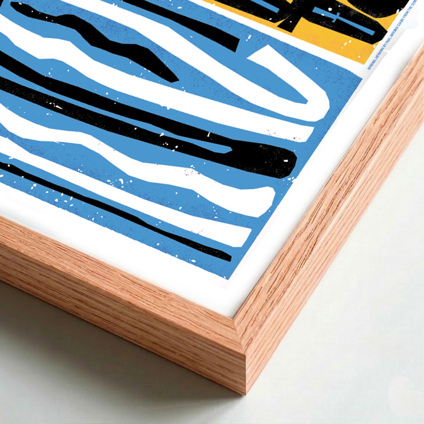 Abstract art print with blue, black, and white stripes in a wooden frame.