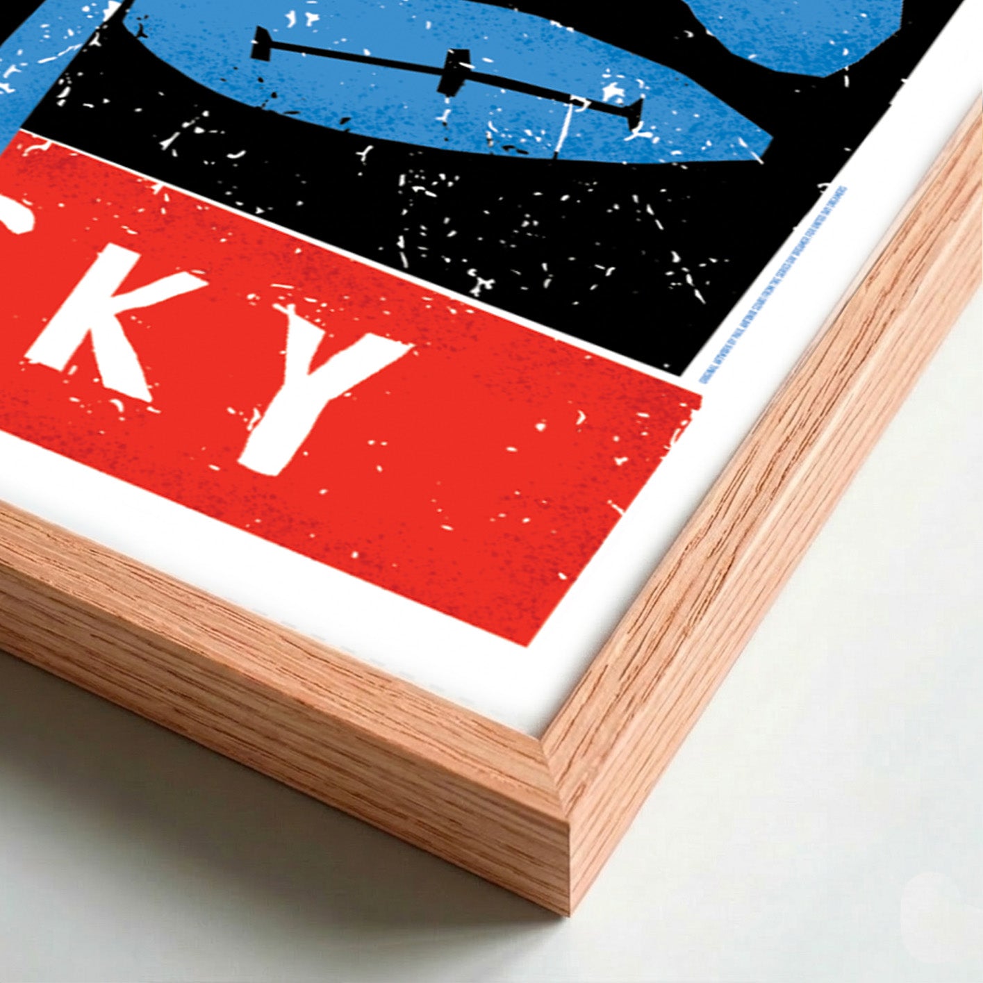 Detail of a framed artwork with abstract design featuring red, blue, and black colors on a white background.