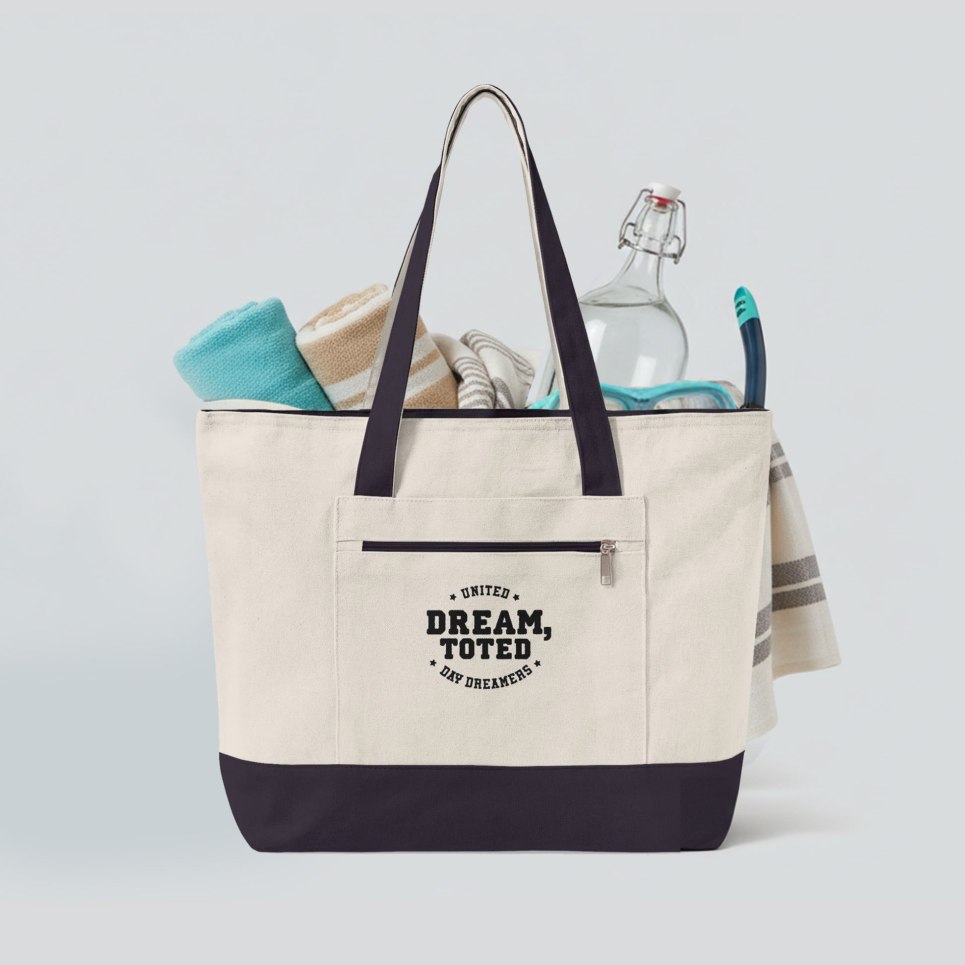 Beige tote bag with dark blue accents and text, filled with items on a light gray background